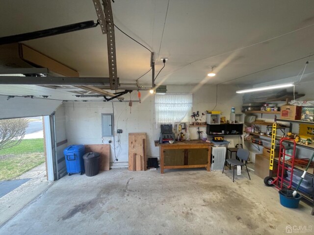 garage with a workshop area and electric panel