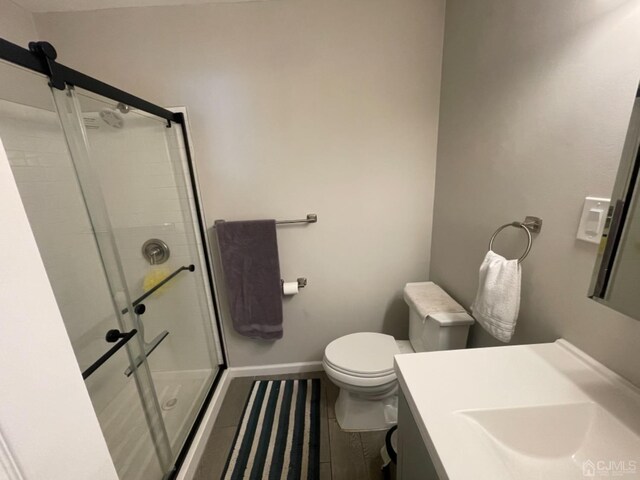 bathroom with hardwood / wood-style flooring, a shower with door, vanity, and toilet