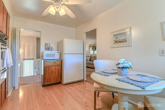 24 Grand Ave, South River, NJ 08882 - kitchen with white appliances, light wood-type flooring, a ceiling fan, and brown cabinetry
