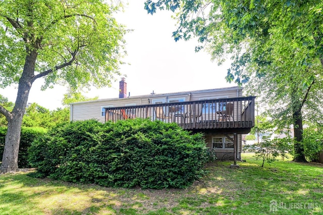 24 Grand Ave, South River, NJ 08882 - back of property with a wooden deck, a chimney, and a lawn