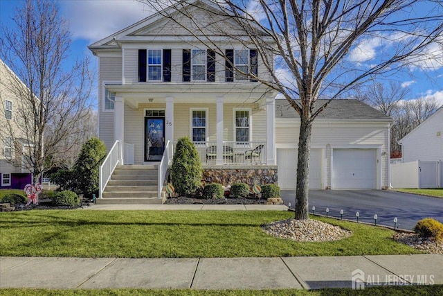 view of front facade featuring a garage, a front lawn, and covered porch