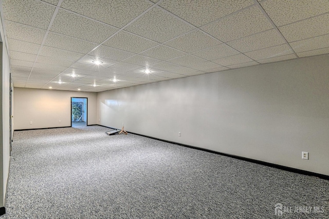 below grade area featuring carpet floors, a paneled ceiling, and baseboards