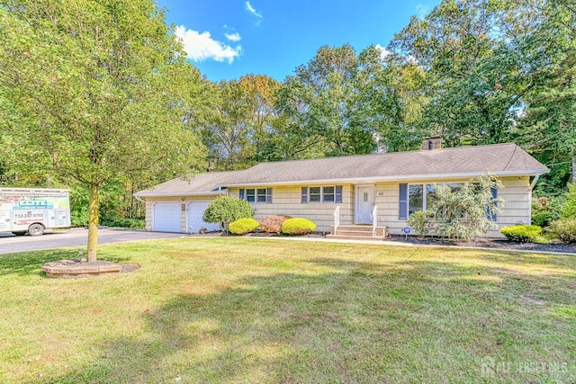 ranch-style home featuring a front yard, driveway, and an attached garage