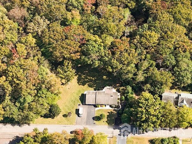 birds eye view of property featuring a forest view