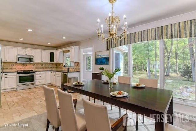 dining space featuring radiator, recessed lighting, stone tile flooring, and an inviting chandelier