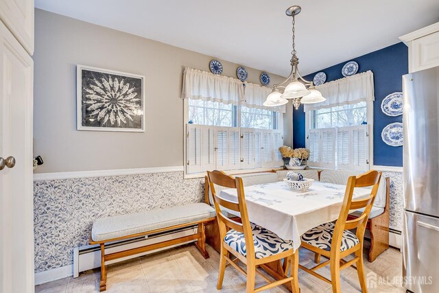 tiled dining area with an inviting chandelier and a baseboard heating unit