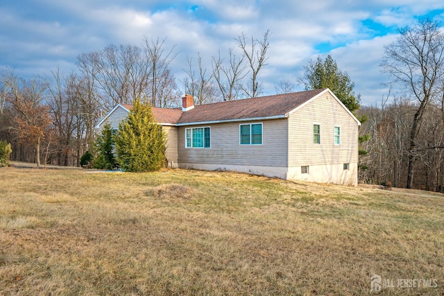 view of side of home with a lawn