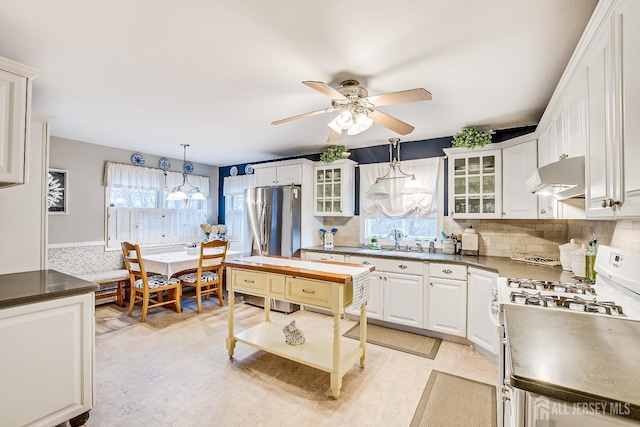 kitchen featuring decorative light fixtures, stainless steel appliances, sink, and white cabinetry