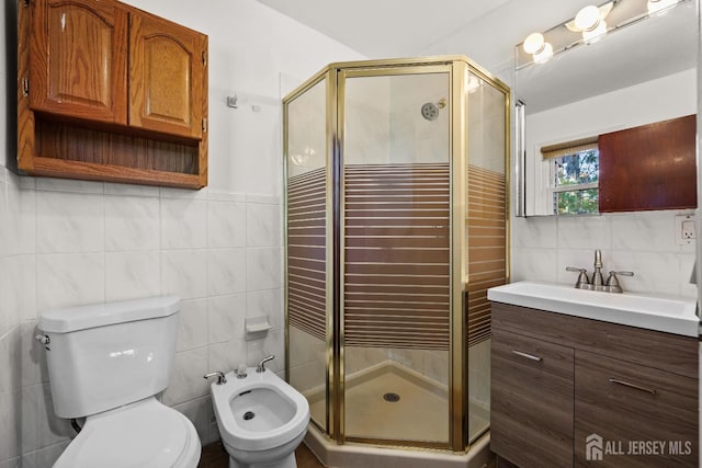 full bathroom featuring a stall shower, a bidet, tile walls, and vanity