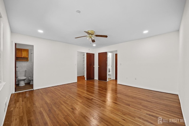 unfurnished bedroom featuring recessed lighting, wood finished floors, and ensuite bathroom