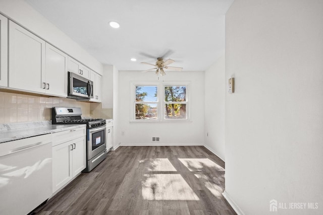 kitchen with tasteful backsplash, visible vents, appliances with stainless steel finishes, dark wood-type flooring, and white cabinetry