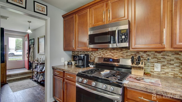 27 Carlton Ave, Monroe, NJ 08831 - kitchen with appliances with stainless steel finishes, brown cabinetry, wood finished floors, and backsplash