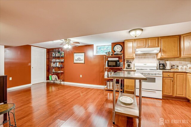 147 Smith St, South Plainfield, NJ 07080 - kitchen with white range with gas cooktop, under cabinet range hood, baseboards, and light wood-style flooring