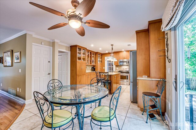 147 Smith St, South Plainfield, NJ 07080 - dining space featuring light tile patterned floors, baseboards, a ceiling fan, and crown molding