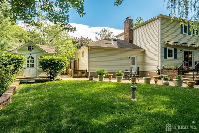 147 Smith St, South Plainfield, NJ 07080 - rear view of property featuring a chimney and a lawn