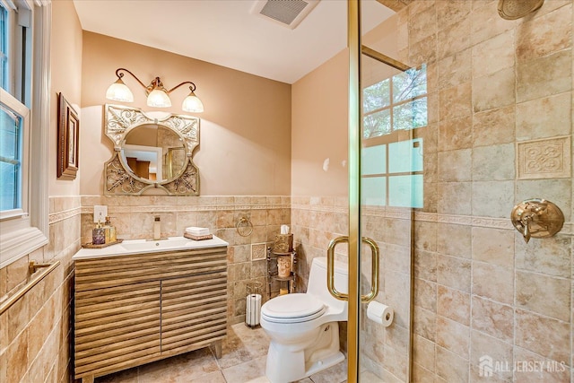 147 Smith St, South Plainfield, NJ 07080 - bathroom featuring tile walls, a stall shower, vanity, toilet, and wainscoting