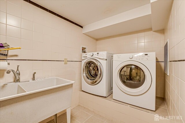 147 Smith St, South Plainfield, NJ 07080 - laundry room with tile walls, separate washer and dryer, and light tile patterned floors