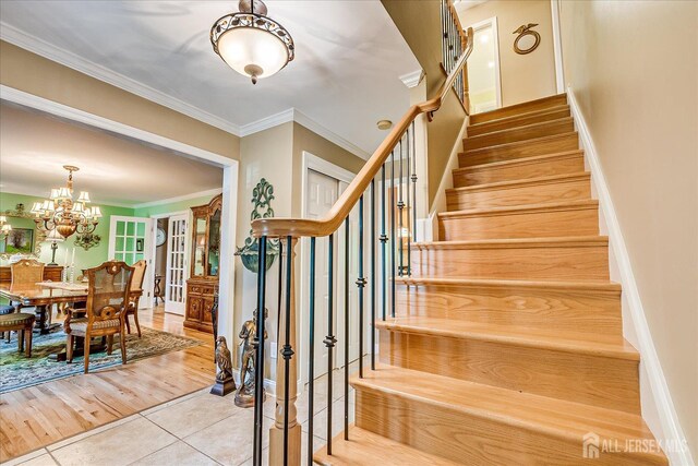 147 Smith St, South Plainfield, NJ 07080 - stairs featuring tile patterned flooring, crown molding, a chandelier, and baseboards