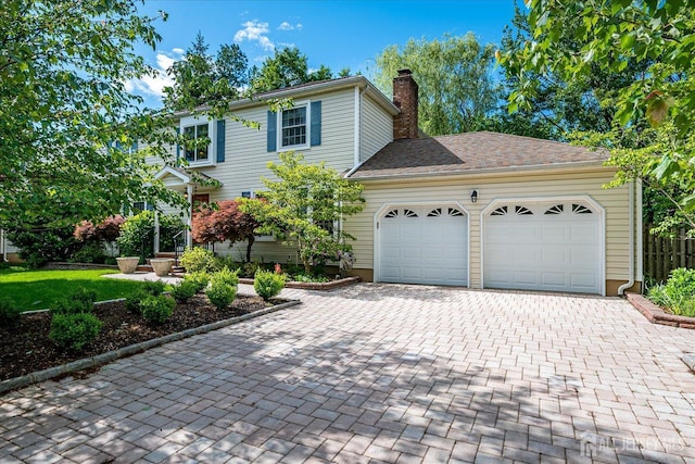147 Smith St, South Plainfield, NJ 07080 - view of front of home featuring an attached garage, decorative driveway, and a chimney