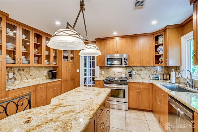 147 Smith St, South Plainfield, NJ 07080 - kitchen with appliances with stainless steel finishes, a sink, brown cabinets, decorative backsplash, and light stone countertops