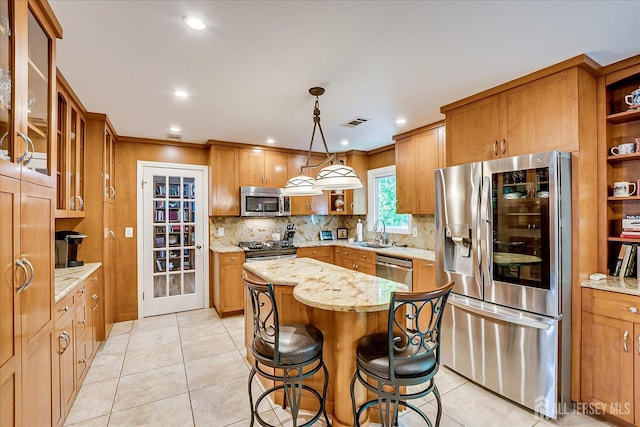 147 Smith St, South Plainfield, NJ 07080 - kitchen featuring stainless steel appliances, a sink, a center island, decorative backsplash, and light stone countertops