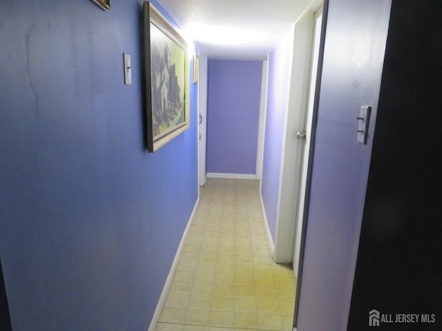 corridor with light floors and baseboards