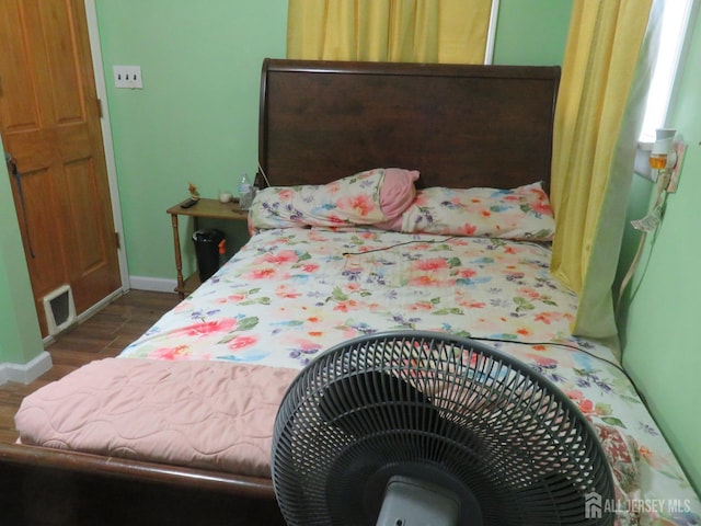 bedroom featuring baseboards and dark wood finished floors