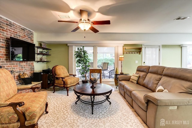 living room featuring visible vents, a fireplace, and ceiling fan