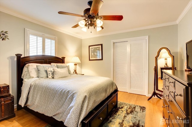 bedroom featuring ceiling fan, a closet, light wood-style flooring, and crown molding