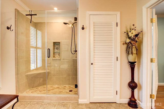 bathroom featuring a stall shower, crown molding, and baseboards