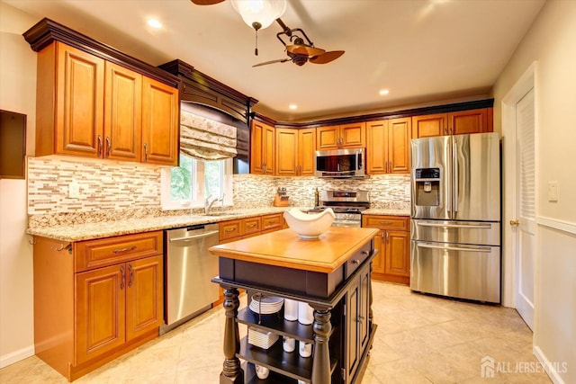 kitchen with open shelves, ceiling fan, a sink, appliances with stainless steel finishes, and backsplash