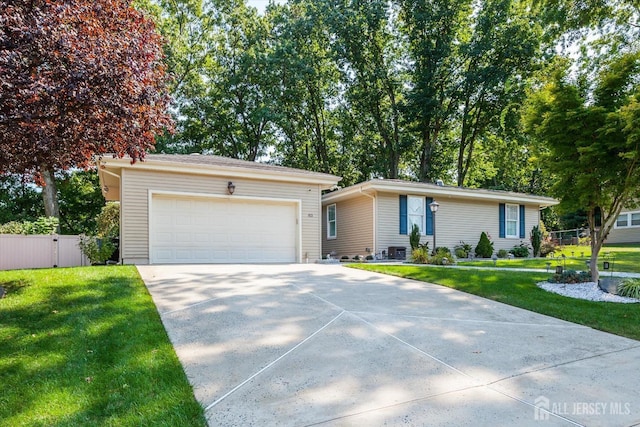 ranch-style house with a garage, a front yard, and fence