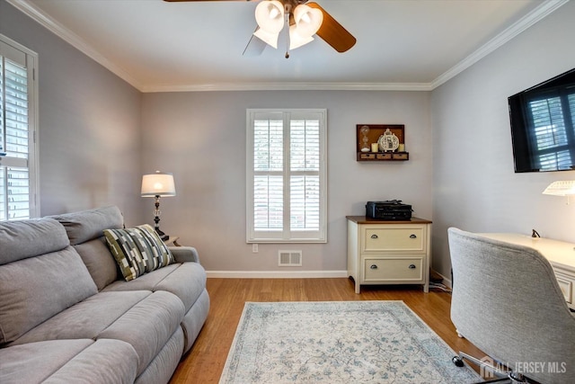 office space featuring visible vents, a ceiling fan, wood finished floors, crown molding, and baseboards