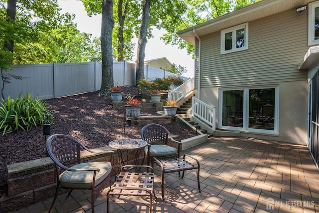 view of patio / terrace featuring stairs and fence