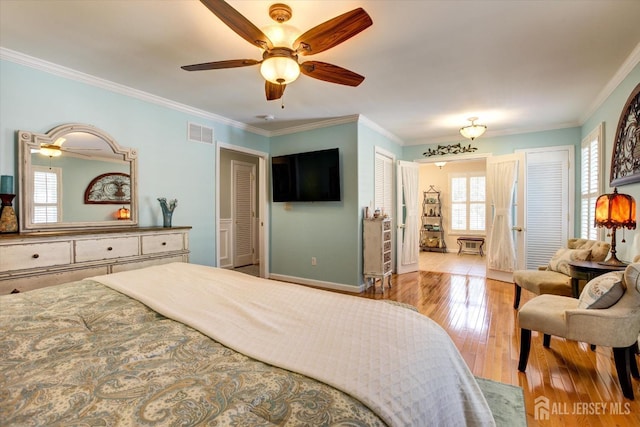 bedroom with visible vents, baseboards, ceiling fan, hardwood / wood-style flooring, and crown molding