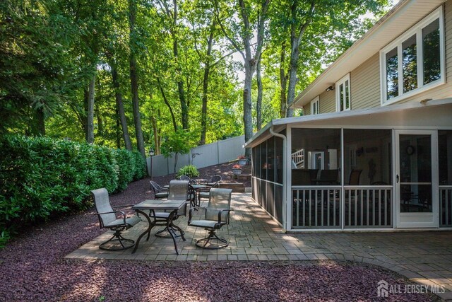 view of patio / terrace with a sunroom and fence