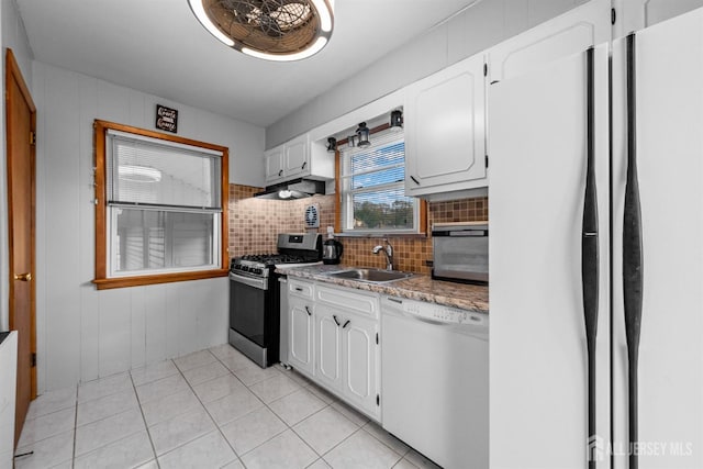 kitchen with freestanding refrigerator, tasteful backsplash, a sink, dishwasher, and gas stove