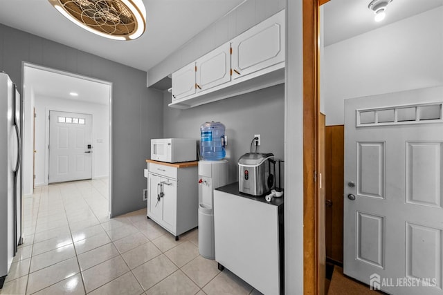 130 Cumberland St, South Plainfield, NJ 07080 - kitchen with white microwave, white cabinets, light tile patterned floors, and freestanding refrigerator