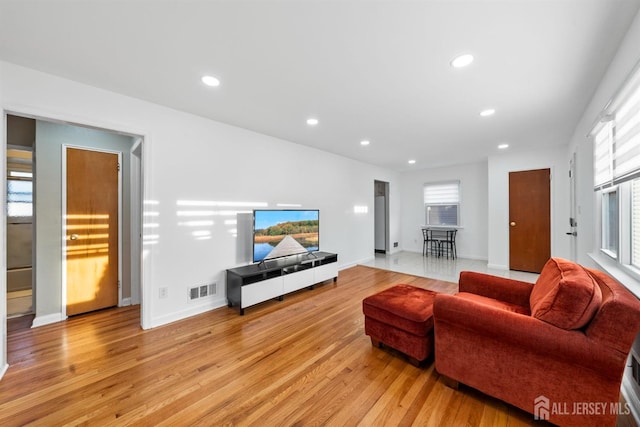 living room with light wood-style floors, recessed lighting, baseboards, and visible vents