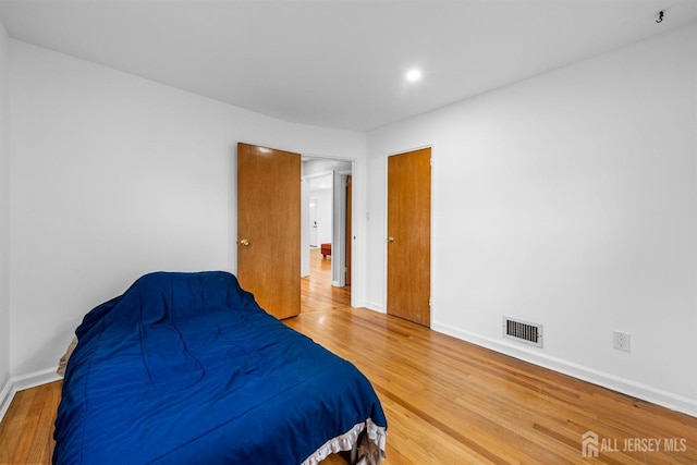 bedroom featuring baseboards, recessed lighting, wood finished floors, and visible vents