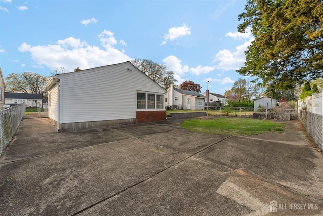 rear view of house with a lawn, a patio, and a fenced backyard