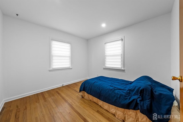bedroom with recessed lighting, baseboards, and wood finished floors