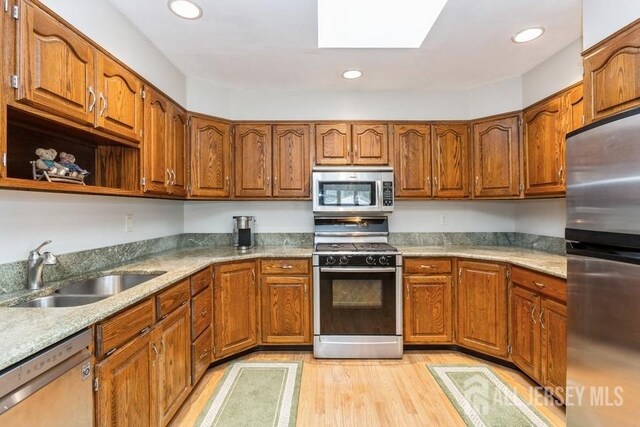 2338 Oxford Ave, South Plainfield, NJ 07080 - kitchen with appliances with stainless steel finishes, light wood finished floors, brown cabinets, and recessed lighting