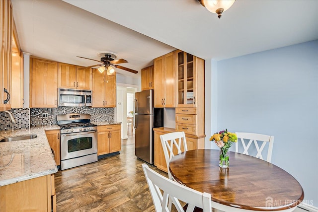 205 Midland Ave, Metuchen, NJ 08840 - kitchen with stainless steel appliances, decorative backsplash, ceiling fan, light stone counters, and glass insert cabinets