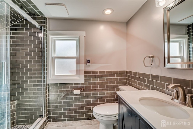 205 Midland Ave, Metuchen, NJ 08840 - bathroom with tile walls, a stall shower, vanity, a wainscoted wall, and tile patterned floors