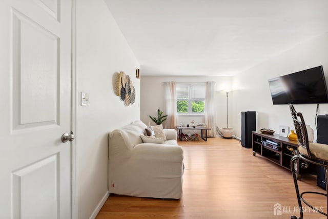 living area with light wood-type flooring and baseboards