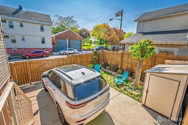 view of patio featuring an outdoor structure, fence private yard, and a detached garage