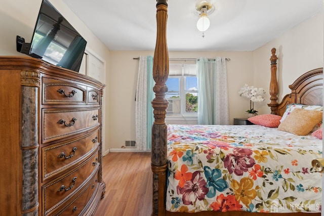 bedroom with light wood finished floors, baseboards, and visible vents