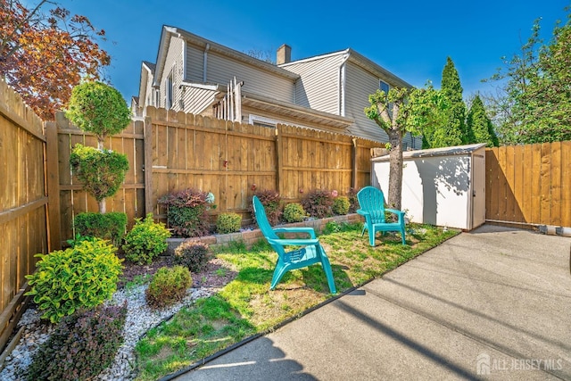 exterior space featuring a patio area, an outdoor structure, a fenced backyard, and a storage unit