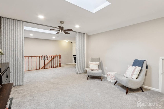 living area featuring an upstairs landing, a skylight, carpet, recessed lighting, and baseboards